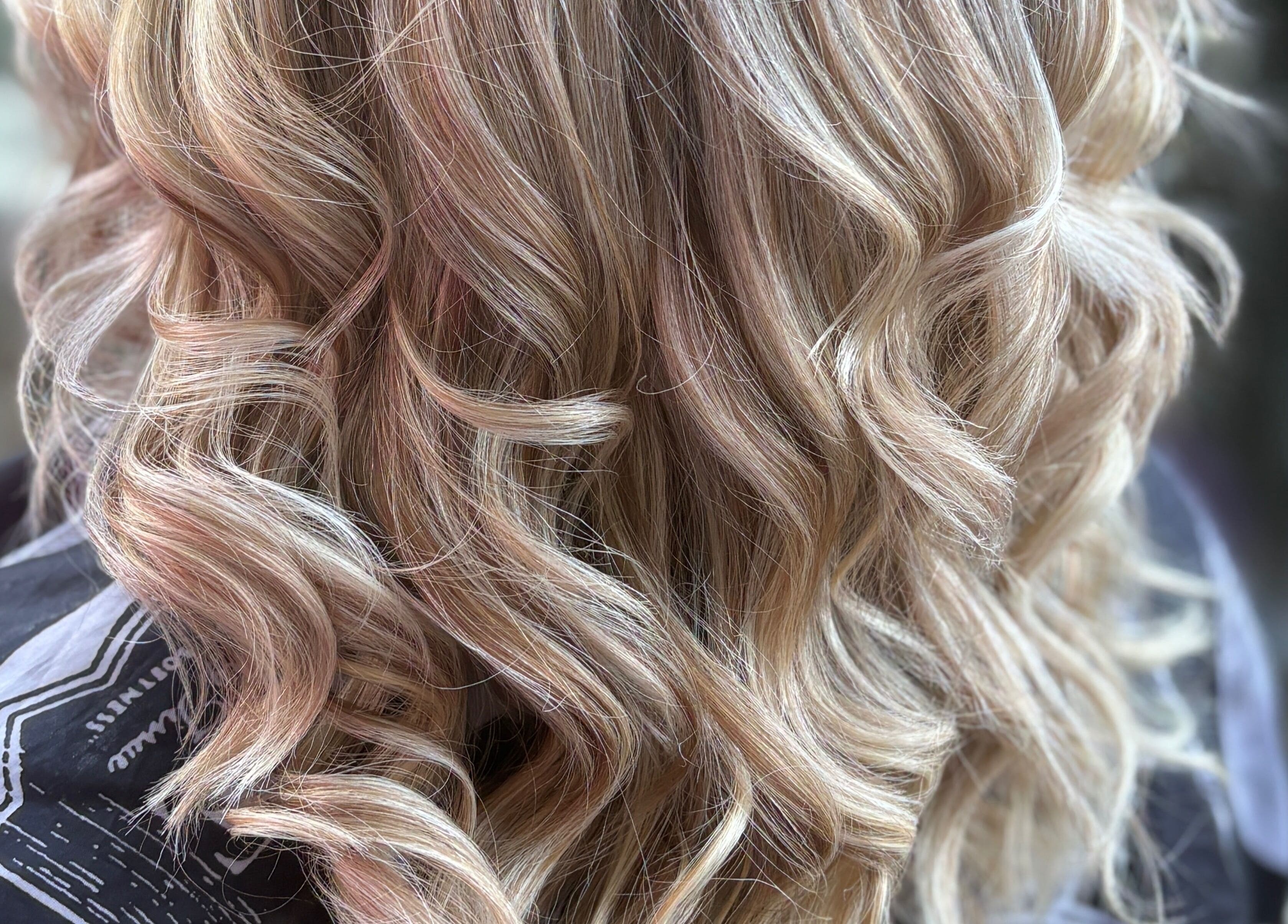 Blonde wavy hairstyle at House of Moira Rose, Thirsk, England, GB, showcasing soft curls and shine.
