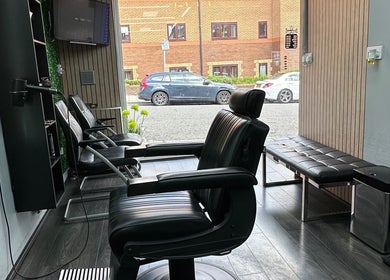 Sleek interior of Smartcut salon in Luton, England, GB, showcasing stylish black barber chairs and modern decor.
