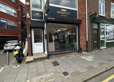 Front of Smartcut hairdresser in Luton, England, GB, showcasing modern street view.
