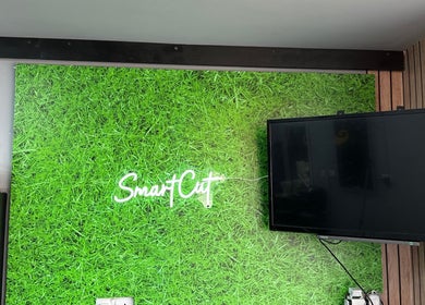 Smartcut signage on vibrant green wall in Luton, England, GB.