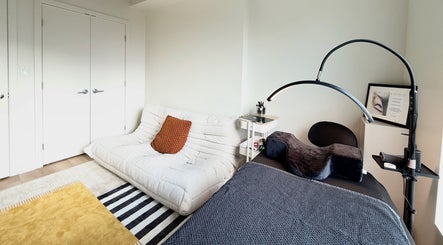 Salle de soin élégante chez La Suite 601 Beauty, Brossard, Québec, CA, avec canapé blanc et décoration moderne.
