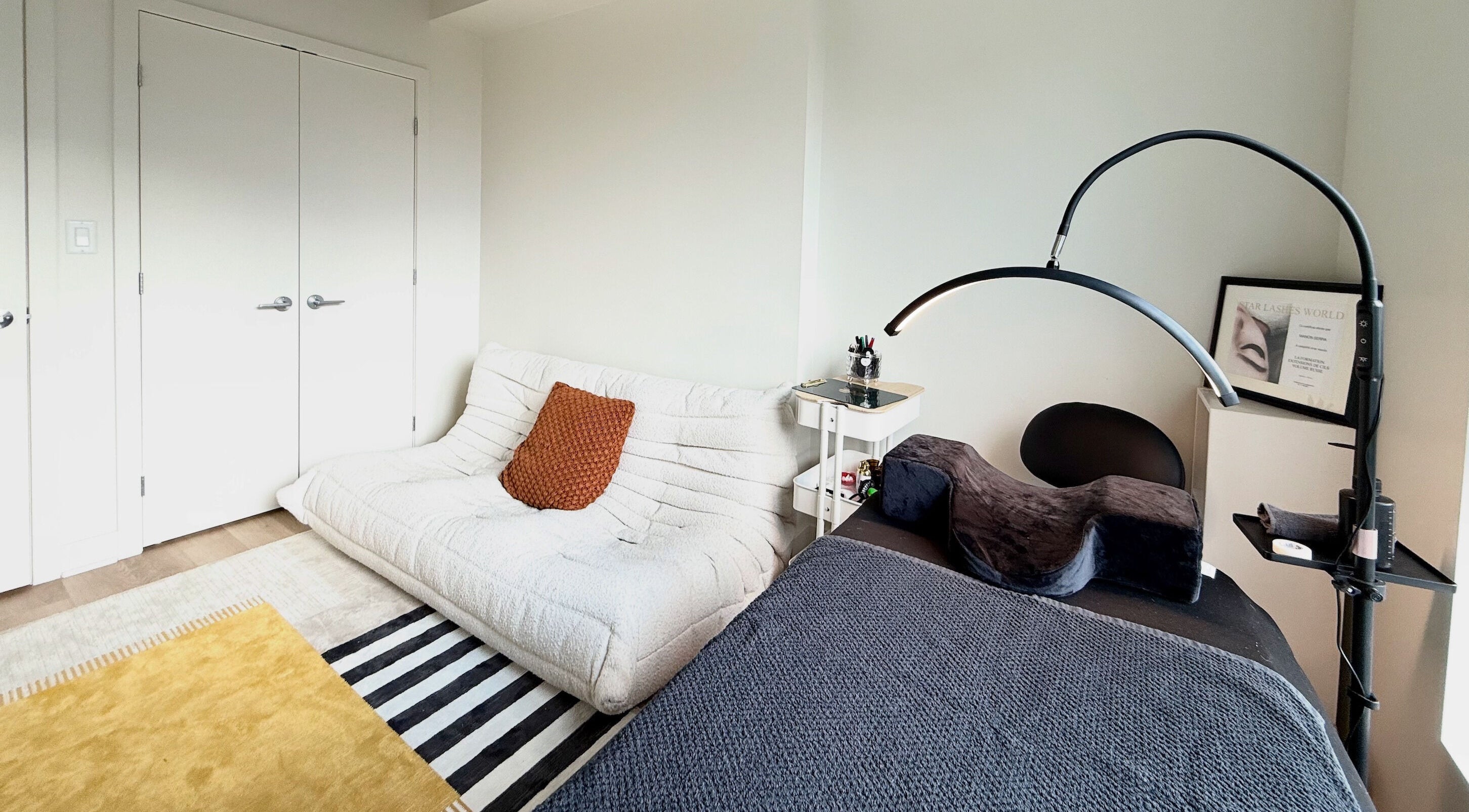 Salle élégante de La Suite 601 Beauty à Brossard, Québec, CA, avec lit de soin et canapé moderne.