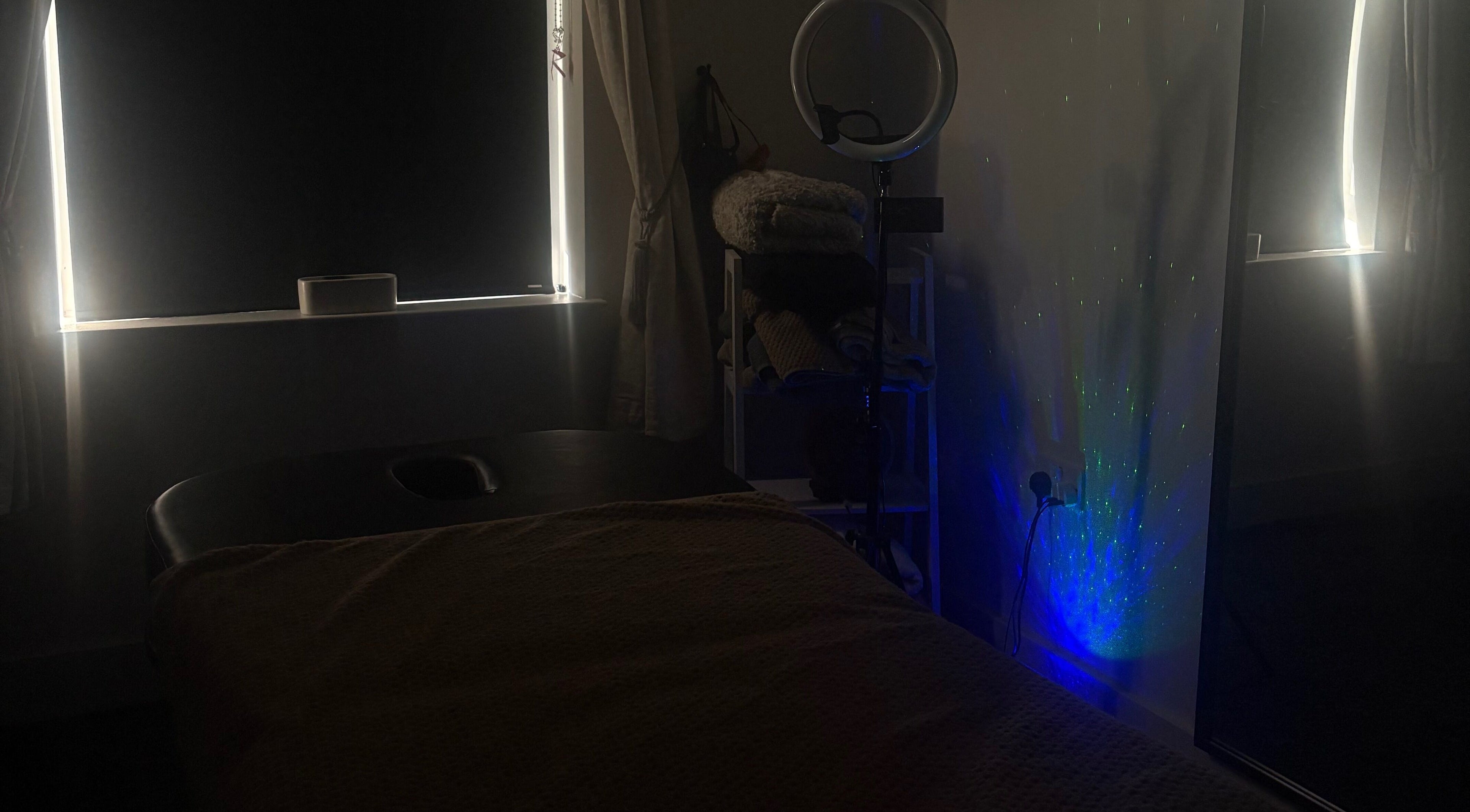 Dimly lit massage room at Tays Sensory Massage in Swansea, Wales, GB with calming lights.