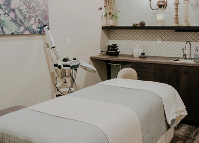 Cozy treatment room at Tenacity Rose Aesthetics in Hyrum, Utah, US, featuring a plush bed and serene decor.