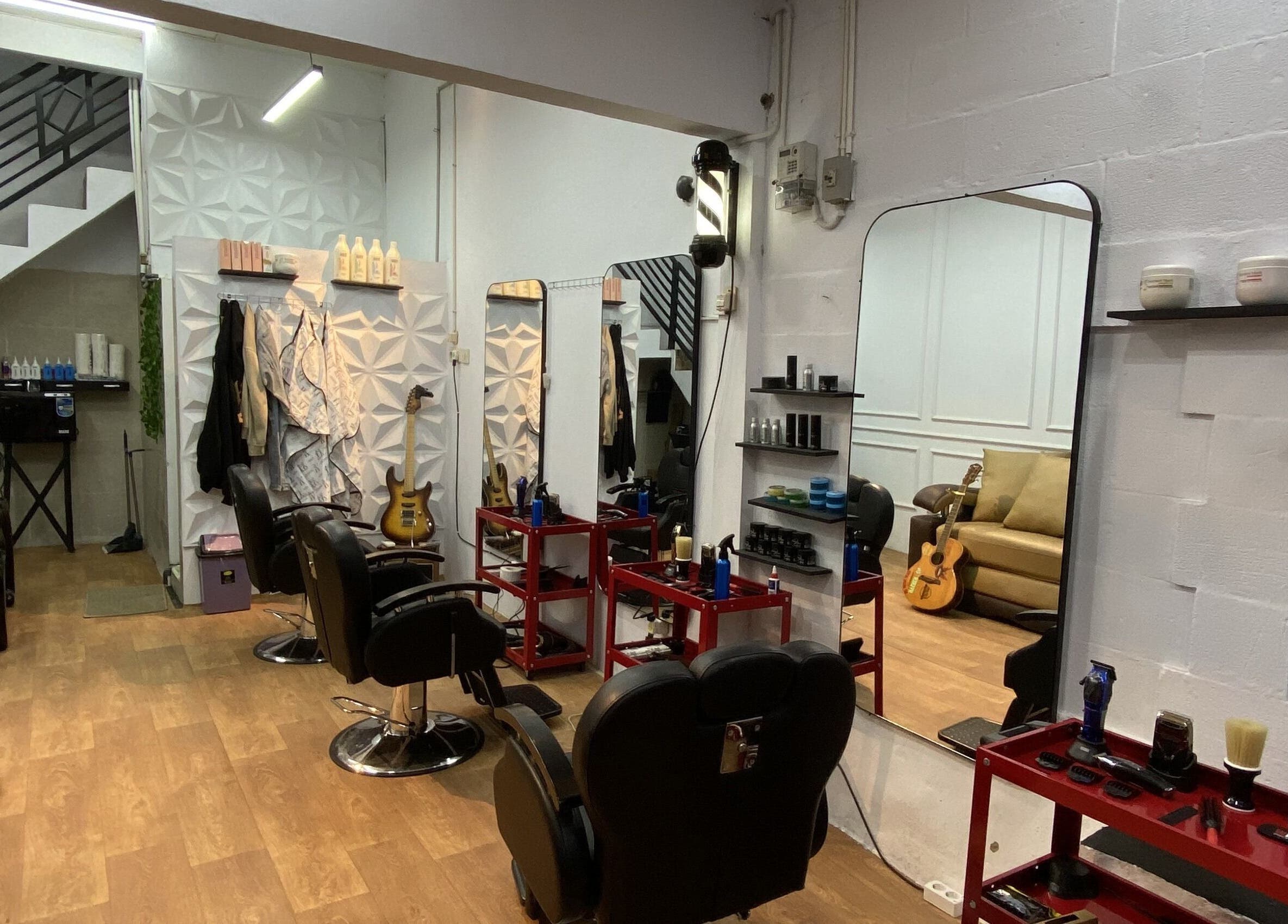 Interior studio Reso Haircut yang elegan di Jawa Barat, Jawa Barat, ID dengan cermin besar dan kursi nyaman.