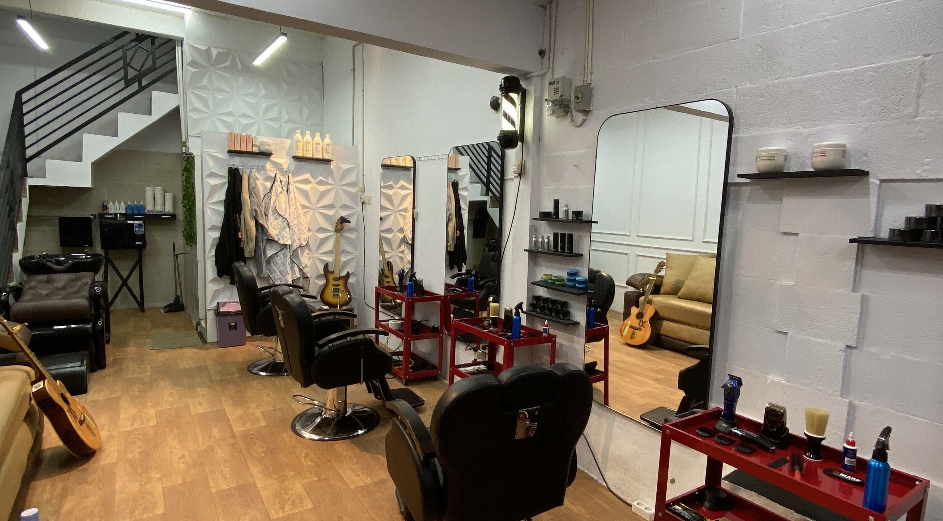 Interior studio Reso Haircut yang elegan di Jawa Barat, Jawa Barat, ID dengan cermin besar dan kursi nyaman.