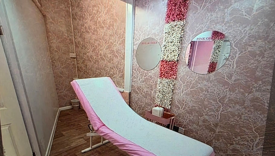 Elegant treatment room at SkinbyTBI, Hornchurch, England, GB, featuring pink decor and floral accents.