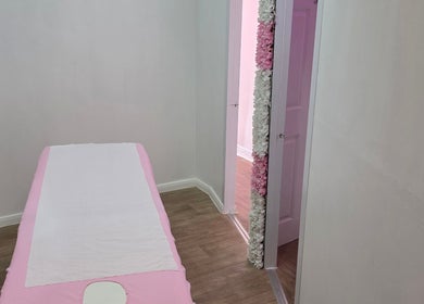 Tranquil treatment room at SkinbyTBI, Hornchurch, England, GB with a pink-themed massage table.