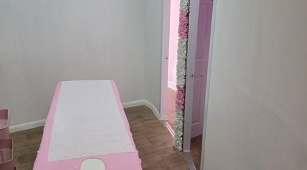 Tranquil treatment room at SkinbyTBI, Hornchurch, England, GB with a pink-themed massage table.