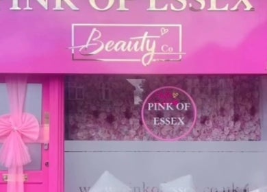 Vibrant pink exterior of SkinbyTBI in Hornchurch, England, GB, showcasing its elegant entrance design.