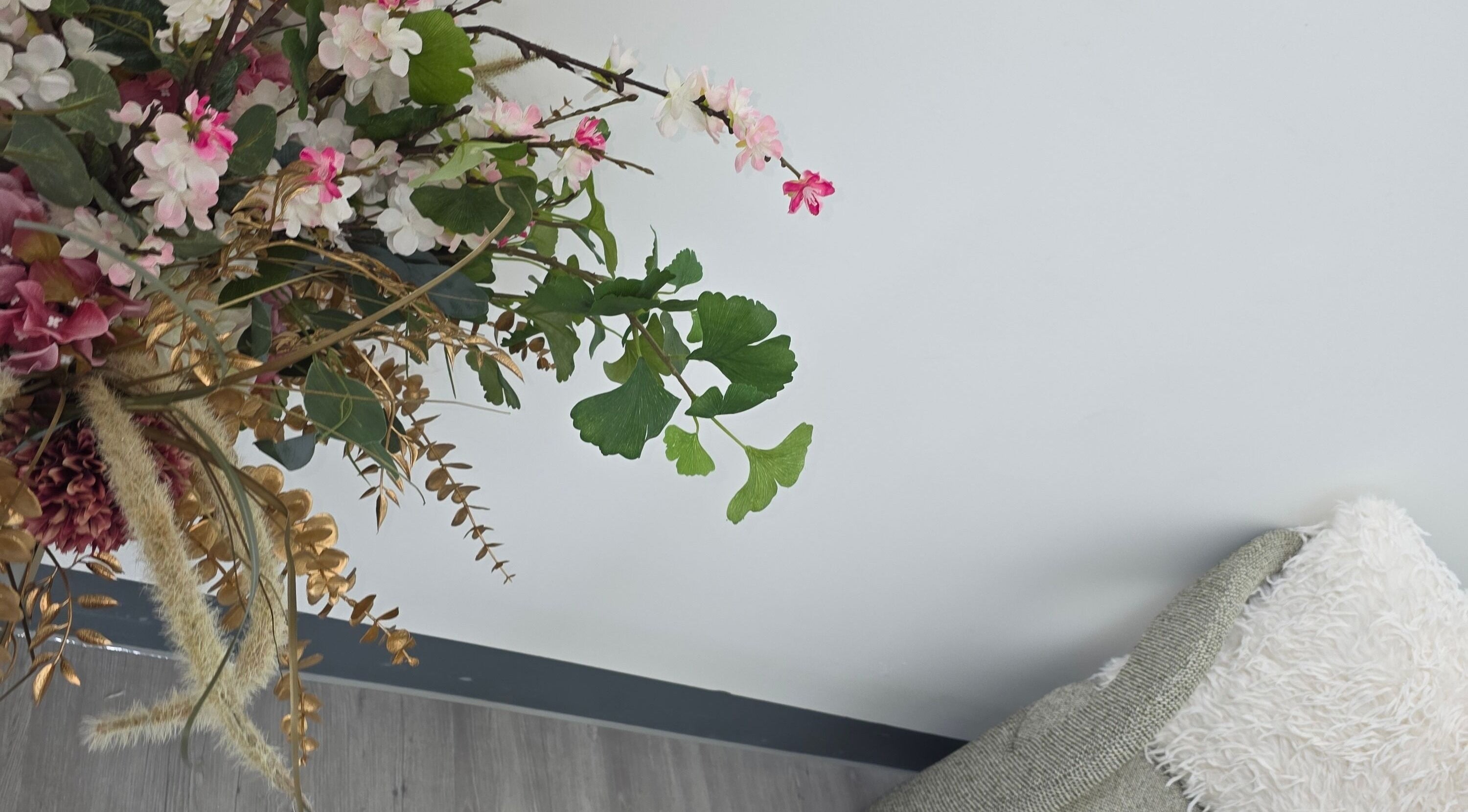 Elegant floral arrangement and cozy pillows at SkinbyTBI, London, England, GB enhancing the tranquil ambiance.