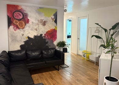 Relaxed waiting area at MPM STUDIO (Chelsea), New York, with modern art and leather sofa.