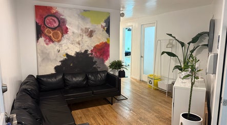 Relaxed waiting area at MPM STUDIO (Chelsea), New York, with modern art and leather sofa.