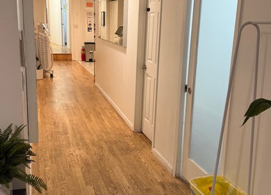 Interior hallway of MPM STUDIO (Chelsea) Mens Grooming in New York, featuring wooden floors and modern decor.