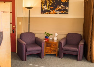 Inviting seating area at Taller De Lo Invisible, Portland, Oregon, US with armchairs and vibrant decor.