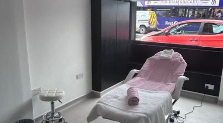 Relaxing treatment room at Laser Luxe Aesthetics in Glasgow, Scotland, GB, featuring a pink-draped chair.