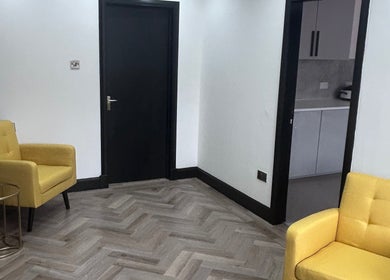 Inviting seating nook at Laser Luxe Aesthetics, Glasgow, Scotland, GB with vibrant yellow armchairs.