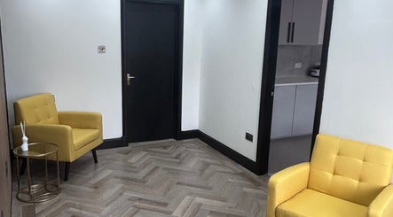 Inviting seating nook at Laser Luxe Aesthetics, Glasgow, Scotland, GB with vibrant yellow armchairs.