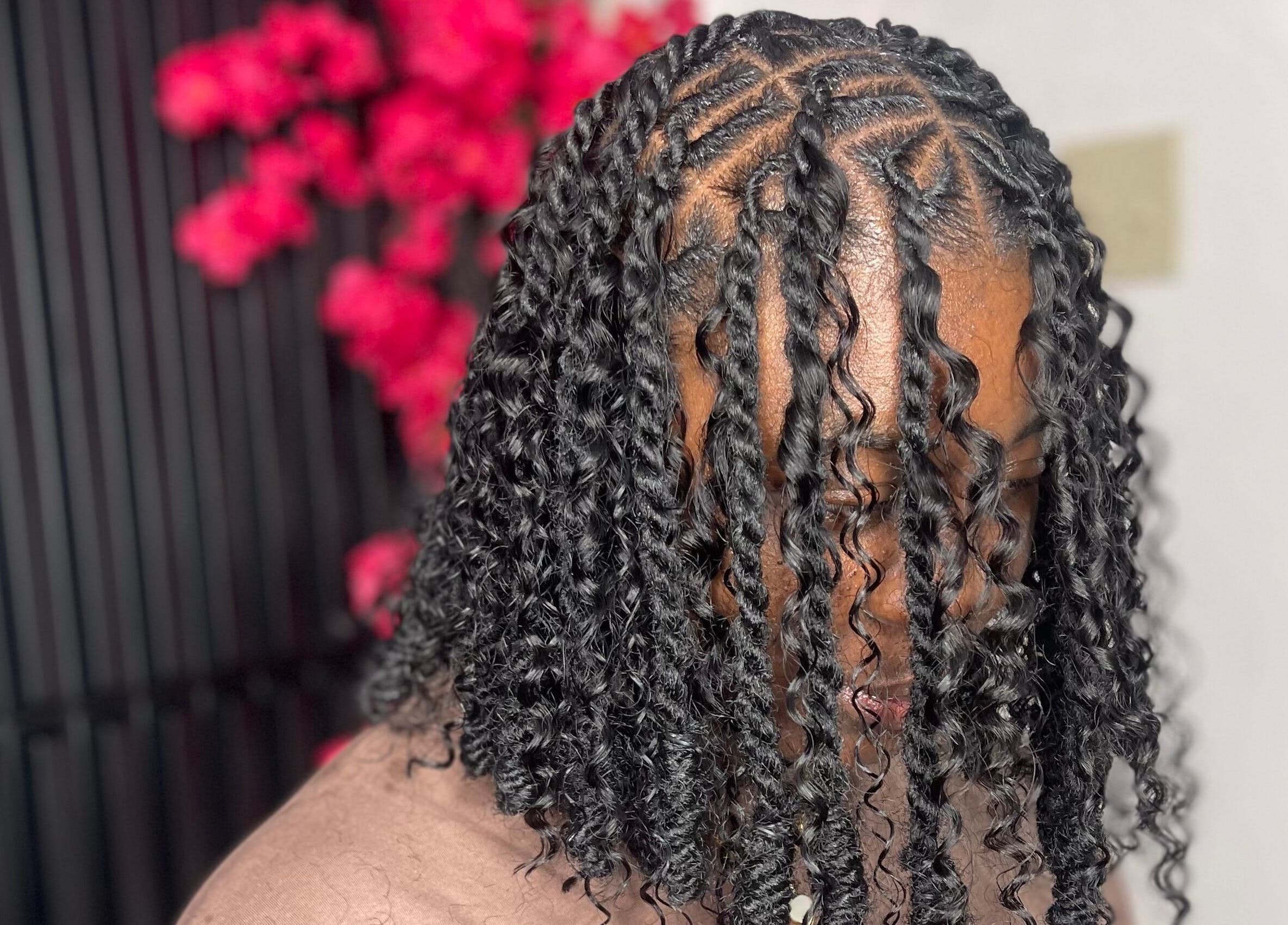 Intricate braided hairstyle at Jadez Beauty Services, Ocho Rios, JM with vibrant background.