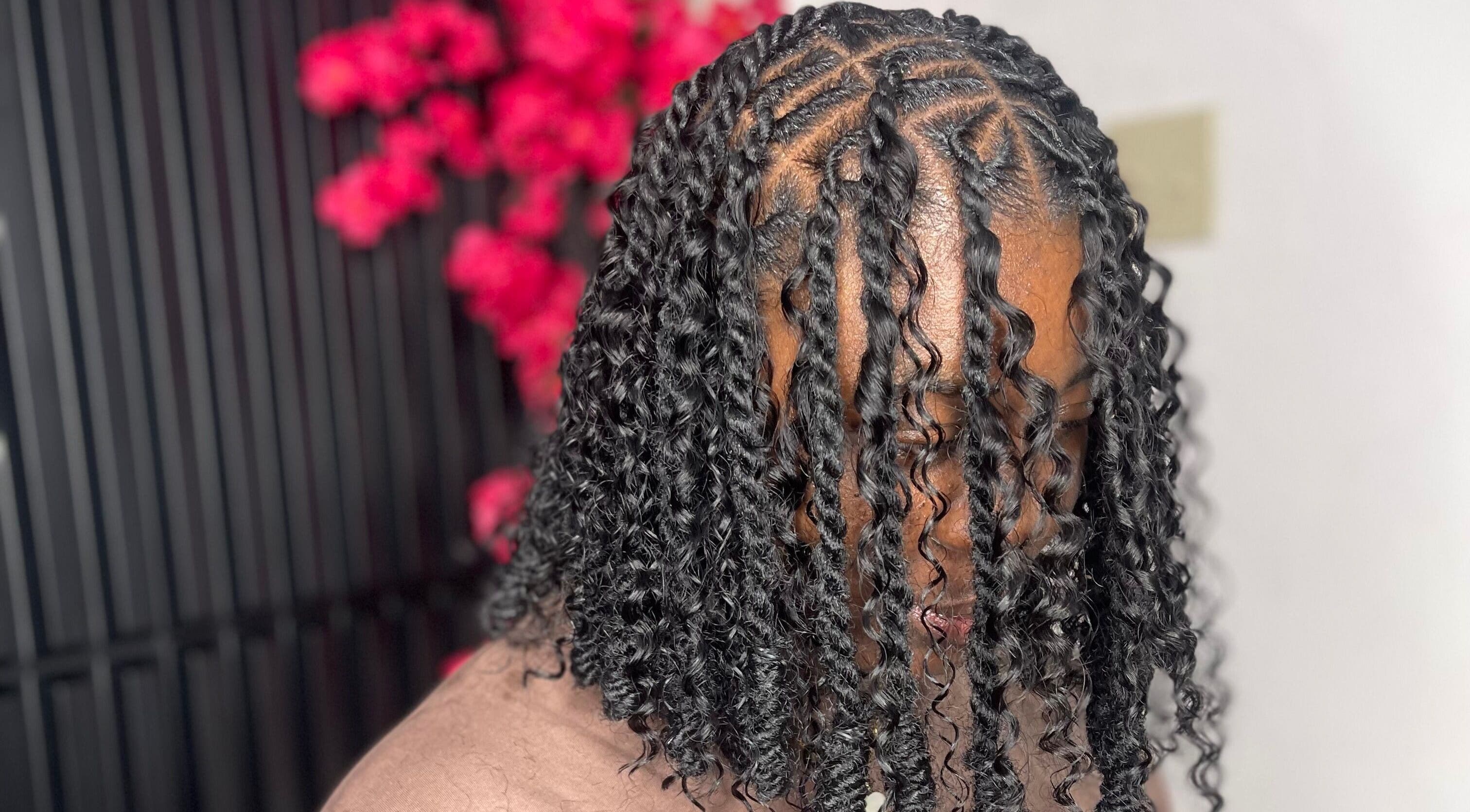 Intricate braided hairstyle at Jadez Beauty Services, Ocho Rios, JM with vibrant background.