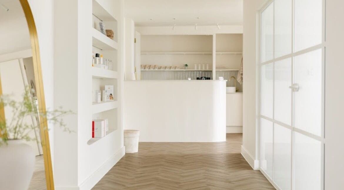 Elegant reception area of The Renewal Room, Hitchin, England, GB, with chic minimalist design and soft lighting.