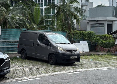 Parking area at Totally Men Wellness, Singapore, Singapore, SG, with vehicles and lush greenery nearby.