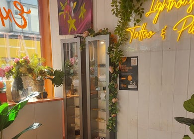 Bright display in Lion Heart Aesthetics And Piercings, Brighton And Hove, with plants and neon sign.
