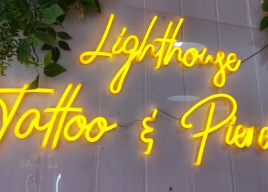 Neon sign inside Lion Heart Aesthetics And Piercings, Brighton And Hove, England, GB with lush green decor.