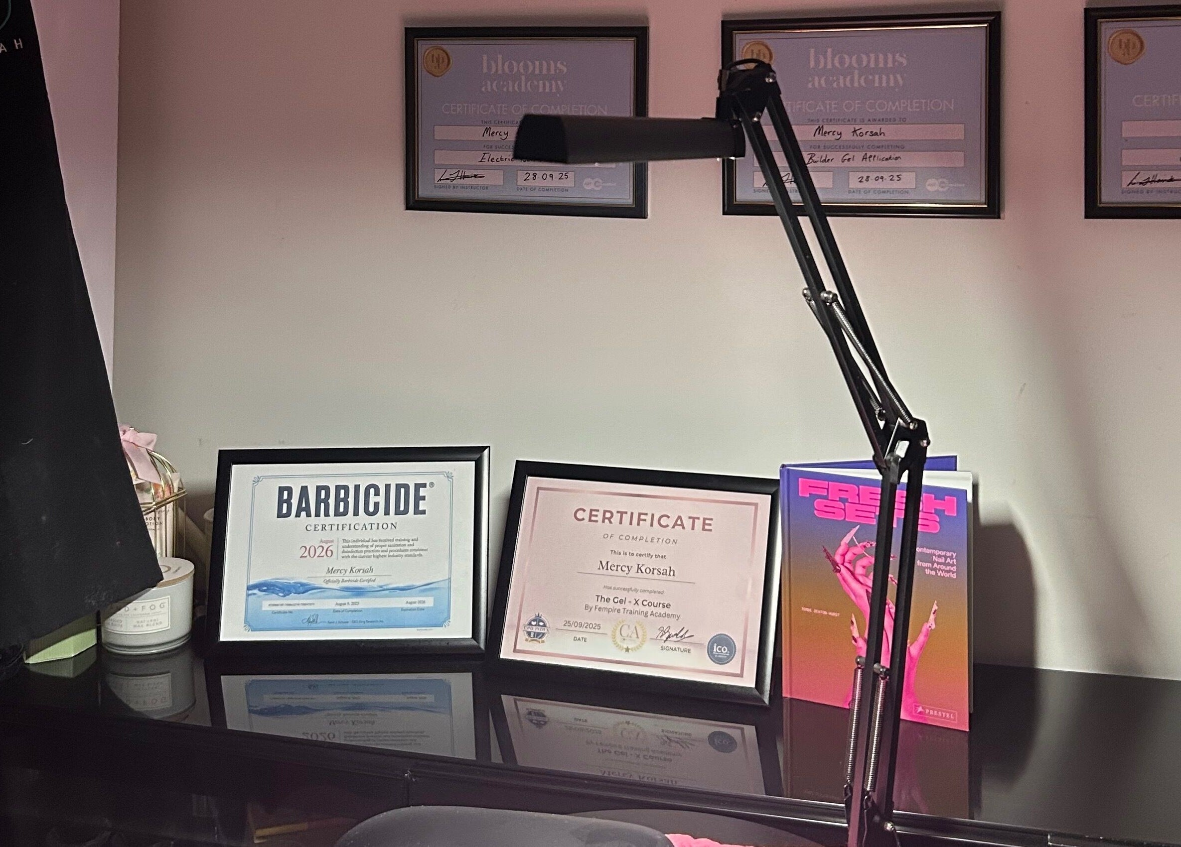 MKDesigns in Harlow, England displays elegant certificates and beauty tools on a sleek desk.