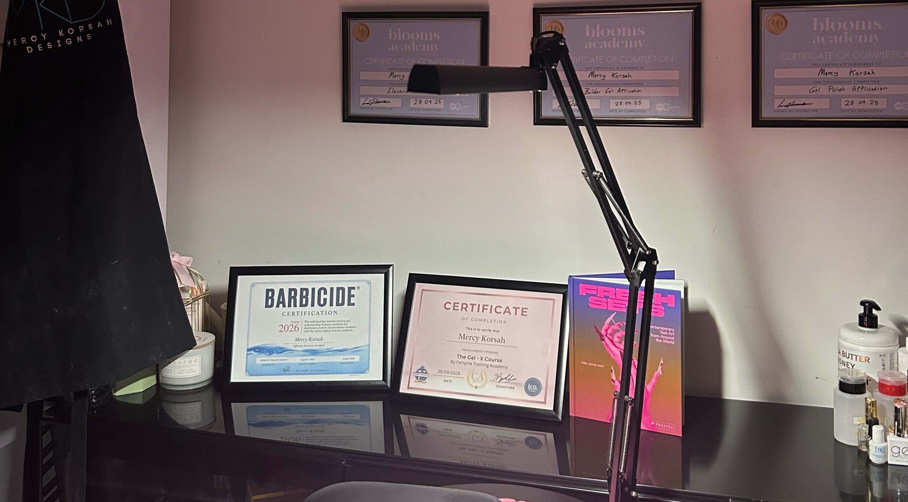 MKDesigns in Harlow, England displays elegant certificates and beauty tools on a sleek desk.
