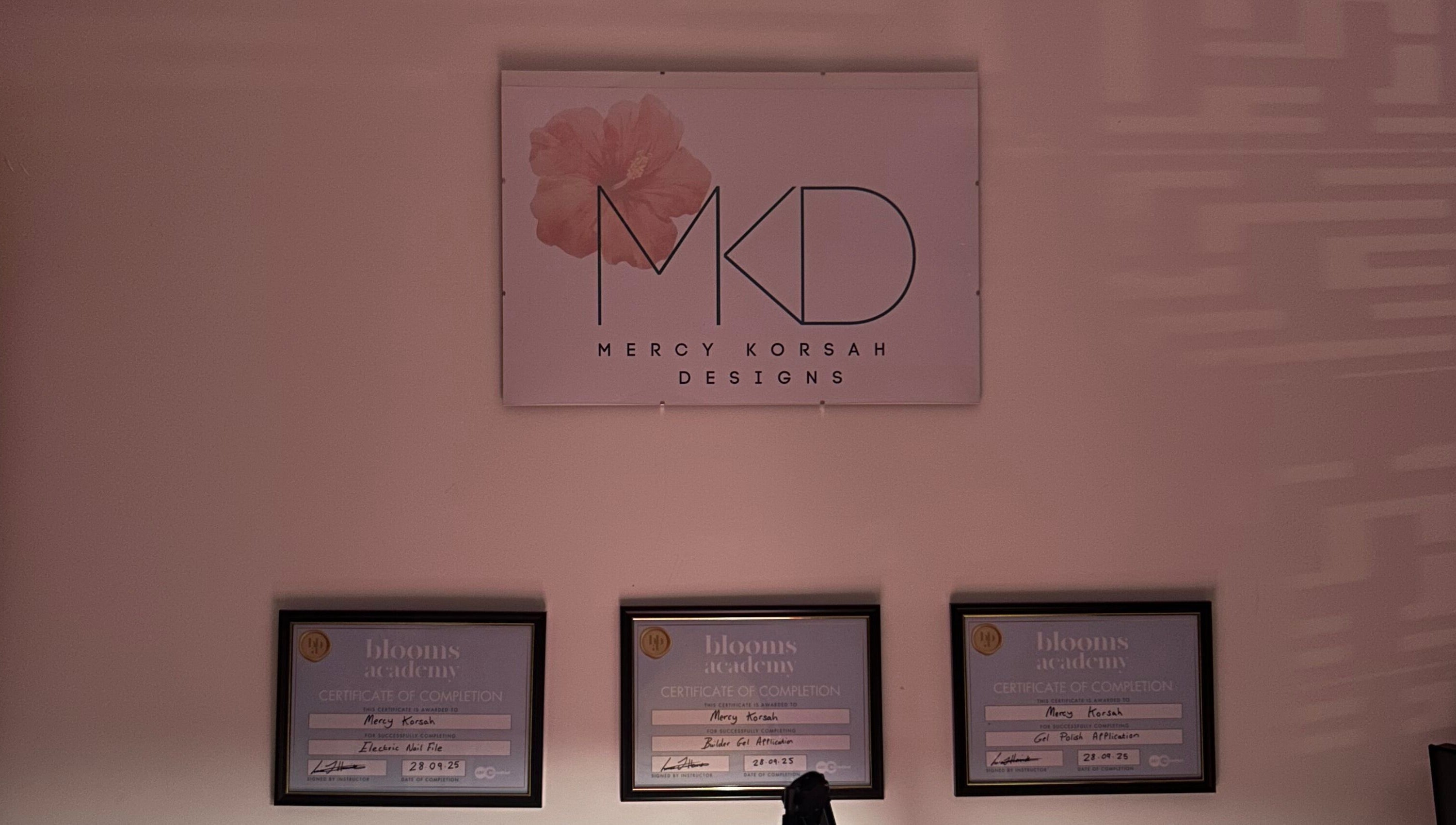 MKDesigns certificate display in Harlow, England, GB with a sleek wall logo and framed certificates.