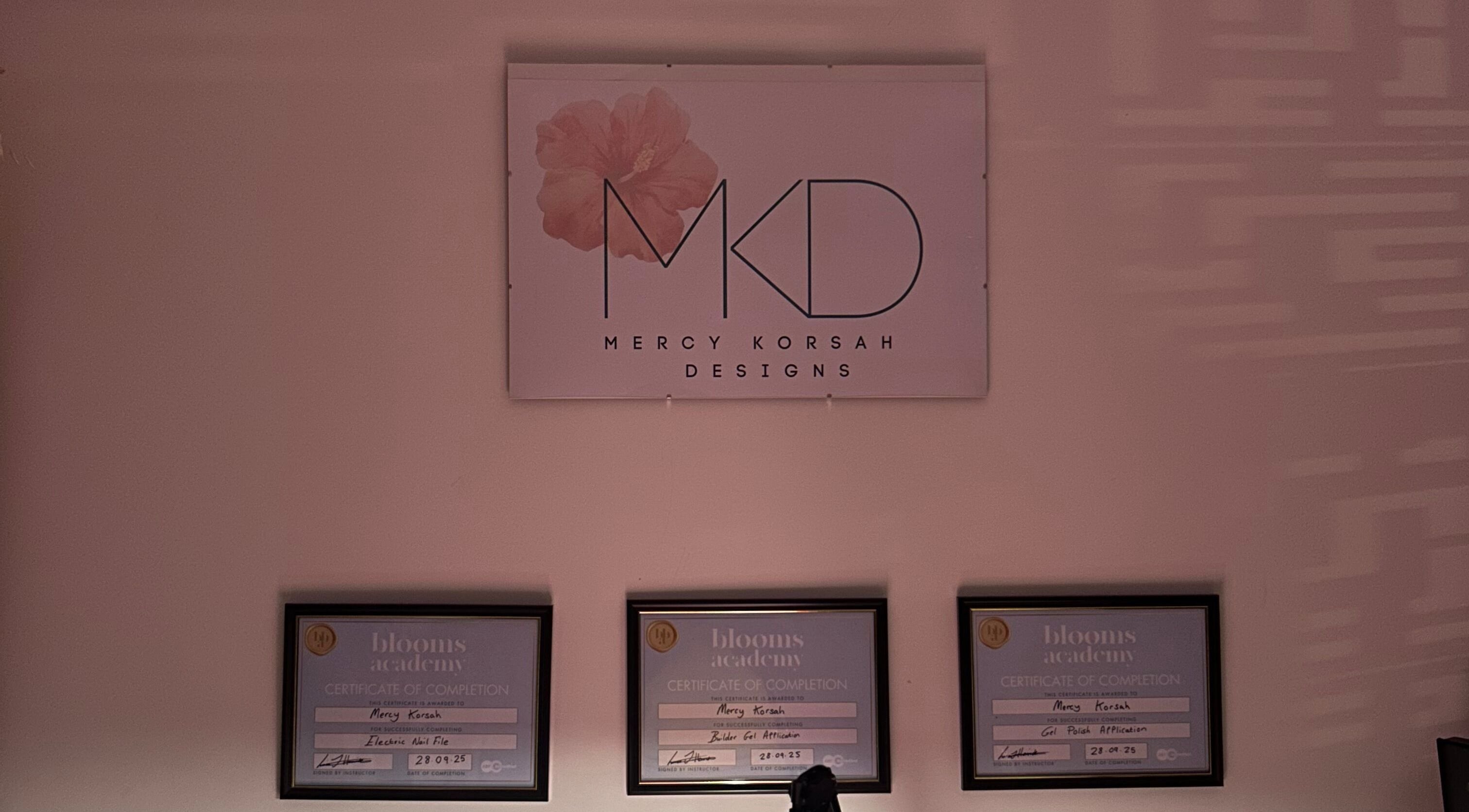 MKDesigns certificate display in Harlow, England, GB with a sleek wall logo and framed certificates.