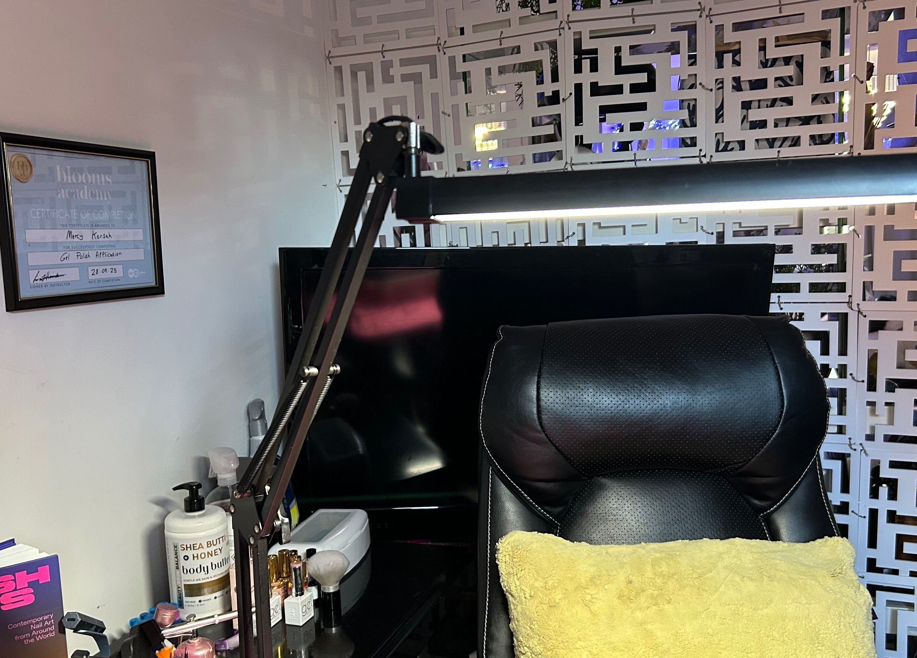 MKDesigns workspace in Harlow, England, GB, featuring a sleek chair, certificates, and beauty essentials.