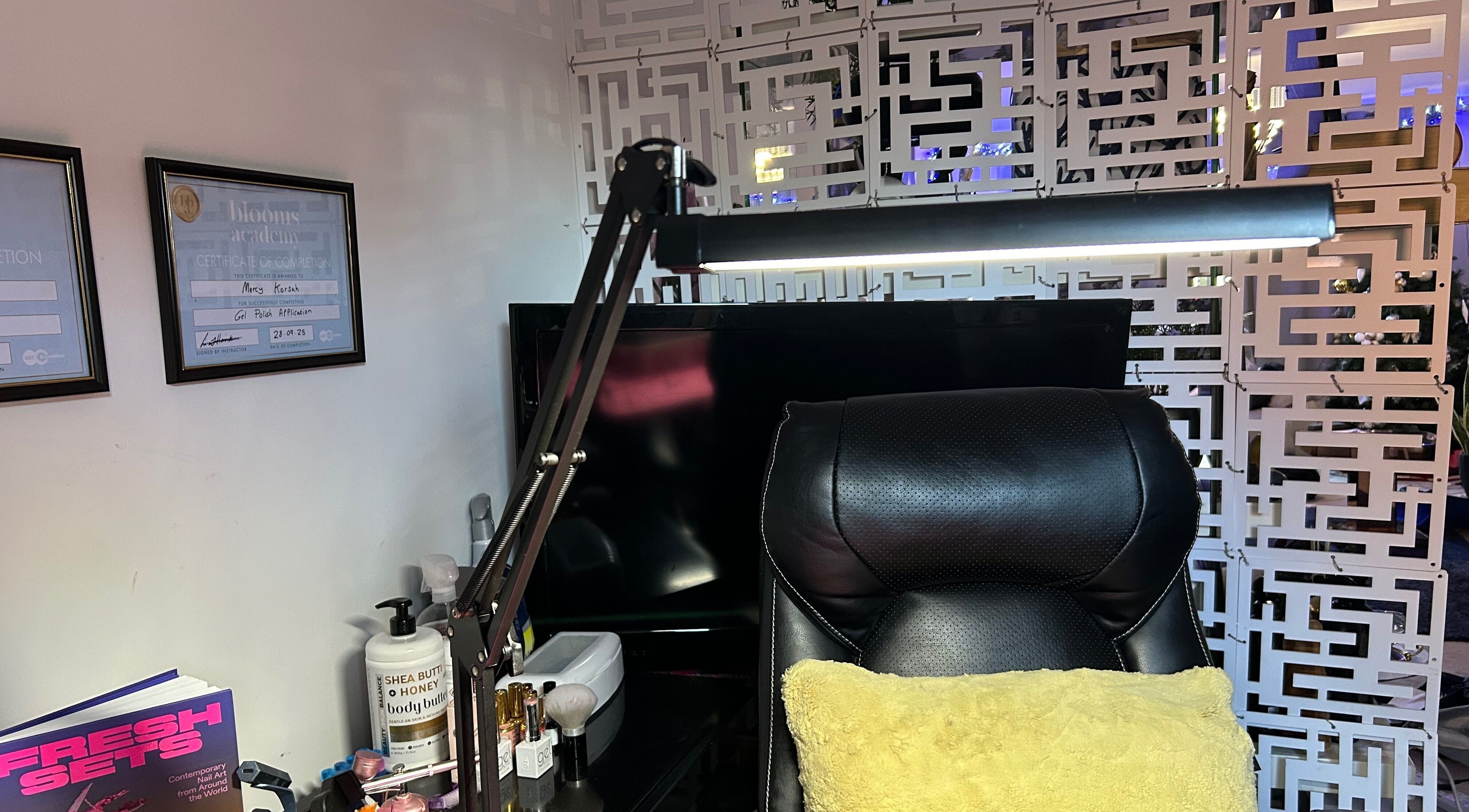 MKDesigns workspace in Harlow, England, GB, featuring a sleek chair, certificates, and beauty essentials.