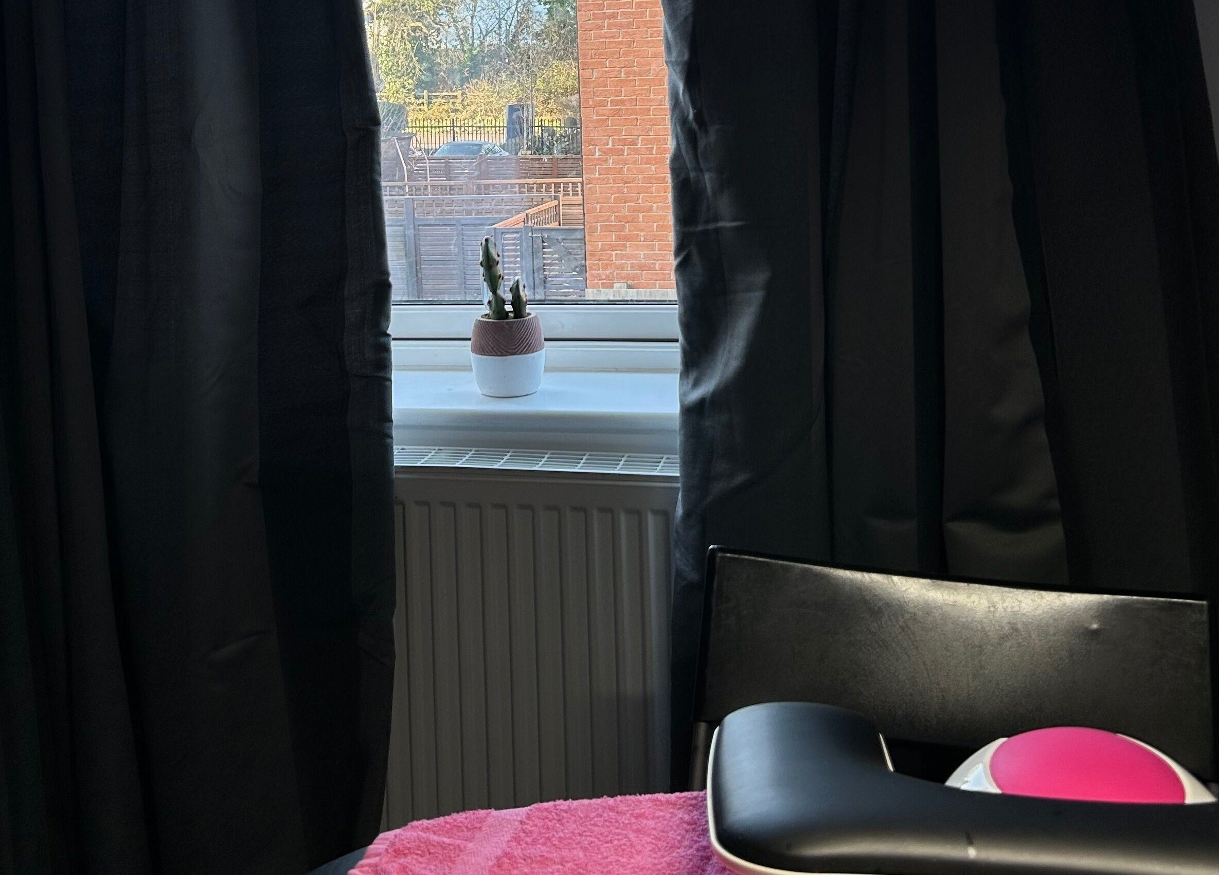 Cozy ambiance at MKDesigns, Harlow, England, GB with a window view and massage chair.