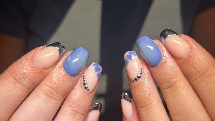 Stylish nail art at Heather Elizabeth Beauty, Bury Saint Edmunds, England, GB with blue hues and metallic tips.
