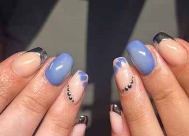 Stylish nail art at Heather Elizabeth Beauty, Bury Saint Edmunds, England, GB with blue hues and metallic tips.