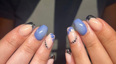 Stylish nail art at Heather Elizabeth Beauty, Bury Saint Edmunds, England, GB with blue hues and metallic tips.