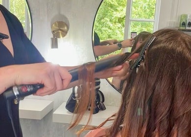 Rachael @seventysix stylist curling woman's hair, mirror reflection, Dunmow, England, GB salon.