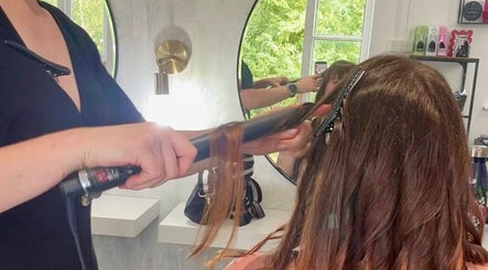 Rachael @seventysix stylist curling woman's hair, mirror reflection, Dunmow, England, GB salon.