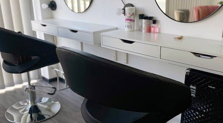 Modern salon station at HEY BEAUTY, Lemesos, CY with mirrors, black chairs, and beauty products.