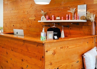 Reception at Classic Beauty Studio, New York, with rustic wood decor and beauty products displayed on shelves.