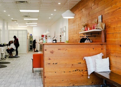 Interior view of Classic Beauty Studio, New York, with stylish wooden decor and salon chairs.