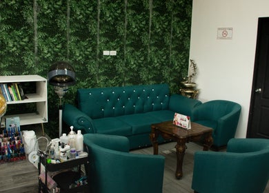 Área de espera elegante en CORONADO BEAUTY SALON, Chame, Provincia De Panamá Oeste, PA con muebles verdes.