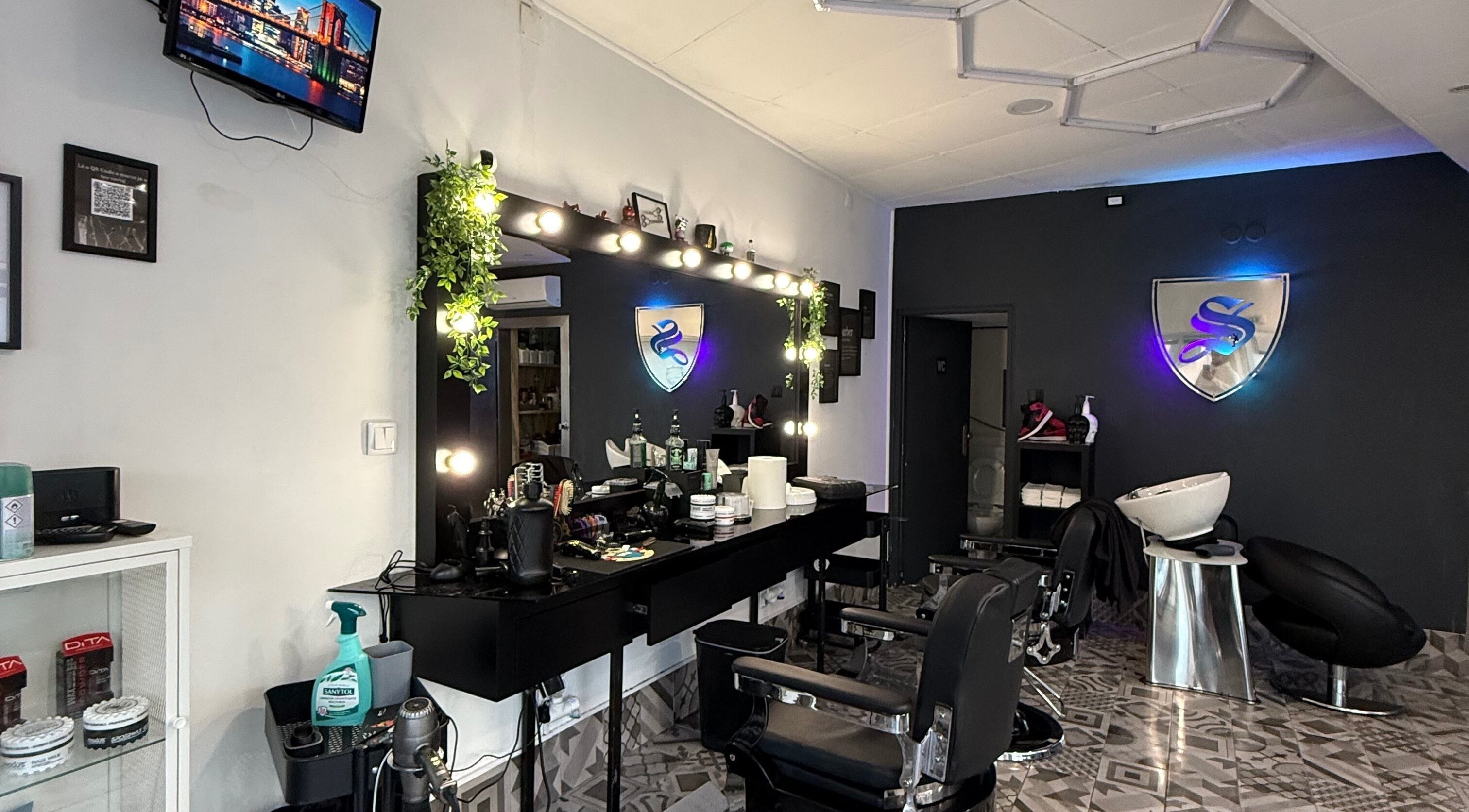 Interior moderno da Barbearia Santana em Maia, Porto, PT com decoração estilizada e cadeiras confortáveis.