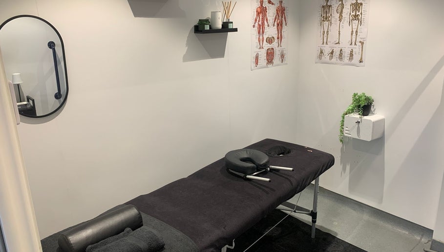 Serene therapy room at Uenjoy Hijama London in Wembley, England, GB with massage table and anatomical posters.