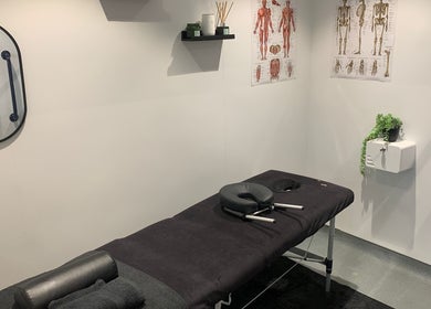 Serene therapy room at Uenjoy Hijama London in Wembley, England, GB with massage table and anatomical posters.