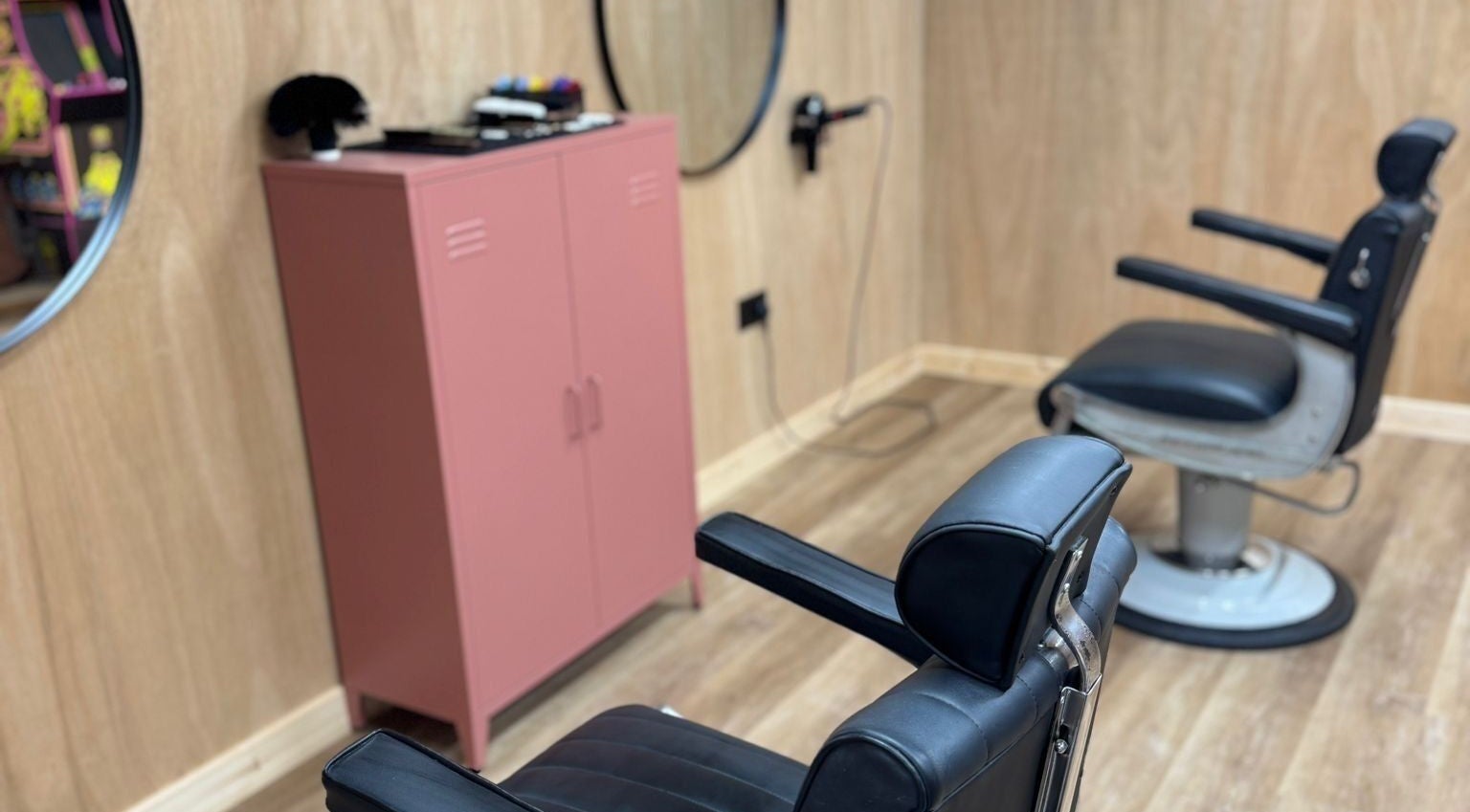 Cozy barber chairs in The Cutting Club, Louth, England, GB, showcasing a stylish wood and leather aesthetic.