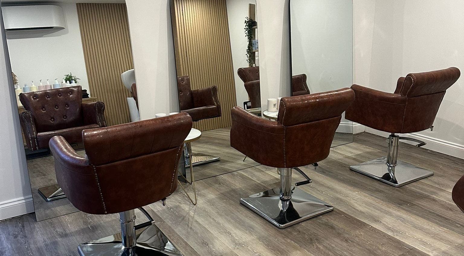 Modern salon seating at C.B Colour, Portishead, England, GB with stylish leather chairs and mirrors.