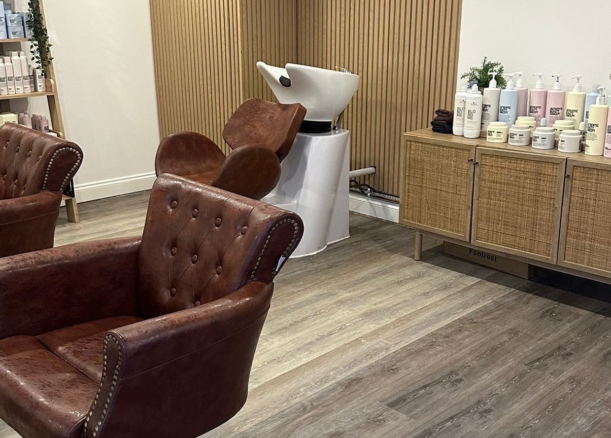 Stylish salon interior at C.B Colour, Portishead, England, GB with leather chairs and beauty products.